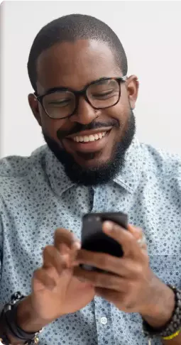 homem utilizando celular e sorrindo