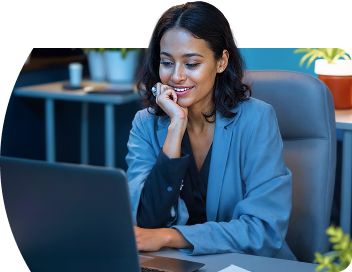 Imagem de uma mulher sorrindo e olhando para o computador