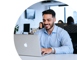 Rapaz sorrindo utilizando um notebook